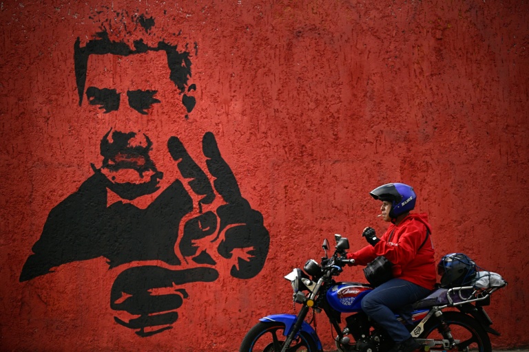 Un homme passe près d'une fresque représentant Nicolas Maduro, le 14 mai 2026 à Caracas
