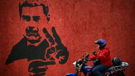 Un homme passe près d'une fresque représentant Nicolas Maduro, le 14 mai 2026 à Caracas