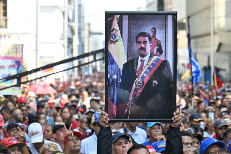 Un partisan du président vénézuélien déchu Nicolas Maduro brandit son portrait lors d'un rassemblement devant l'Assemblée nationale à Caracas le 5 janvier 2026