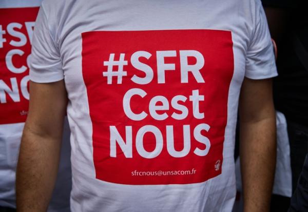 Des salariés de SFR manifestent devant le siège de la maison-mère Altice, à Paris, le 24 septembre 2026, à l'appel des syndicats UNSA, CFDT et CFTC pour protester contre la vente de la société