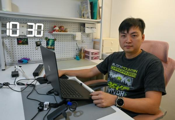 Mark Koh, un investisseur singapourien spécialisé dans les cryptomonnaies et victime d'une escroquerie, devant son écran d'ordinateur lors d'un entretien avec l'AFP chez lui à Singapour, le 30 janvier 2026